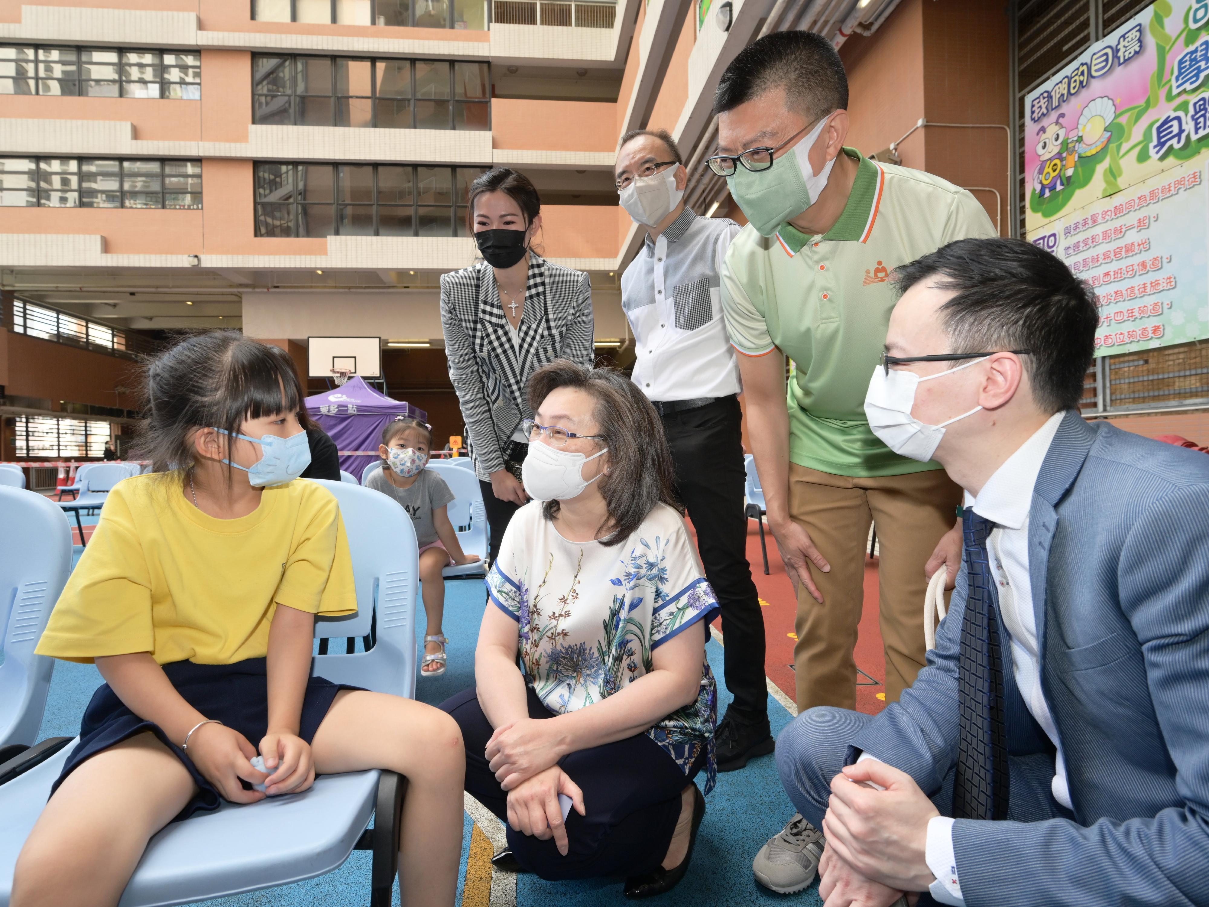 The Secretary for the Civil Service, Mrs Ingrid Yeung, today (October 8) attended the Wan Chai District Student Vaccination Day at SKH St James' Primary School to encourage school children and parents to receive COVID-19 vaccination together. Photo shows Mrs Yeung (front row, centre) chatting with a student (front row, left) who just received her COVID-19 vaccination.
